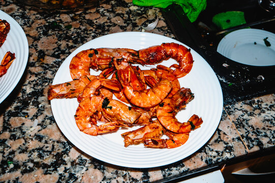 garlic and parsley prawns on a white plate in a home kitchen