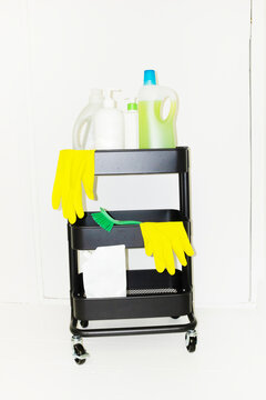 Modern cart filled with cleaning equipment: gloves, brush, detergent