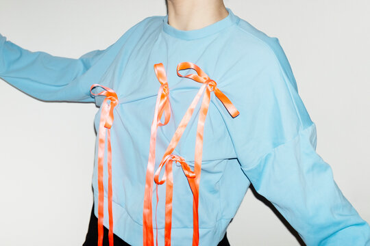 Person wearing a fashion style blue shirt with pink silk ribbon bow 