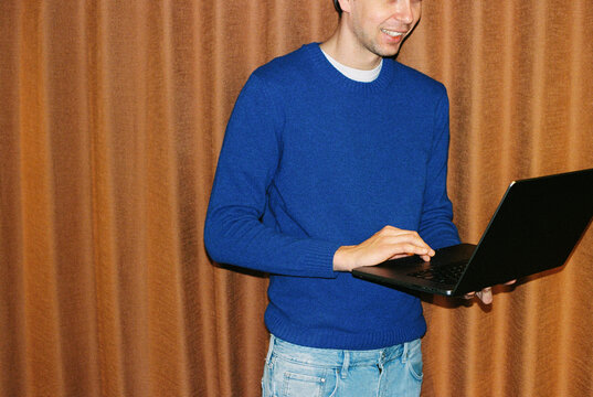 Business Professional in Blue Sweater Using Laptop