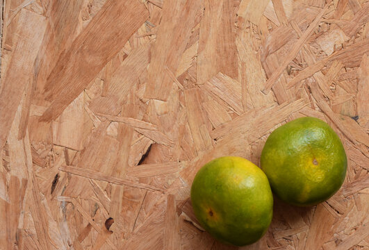 Several mandarines viewed from above on a wooden table, creating a vibrant, fresh, and rustic still-life scene full of natural color and texture.
