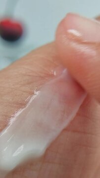 Gently applying white cream thoroughly all over the palm, close up view, blurring wrinkles on the skin. Moisturizing hand cream, anti aging treatment and youthful skin, beauty and wellness concept.