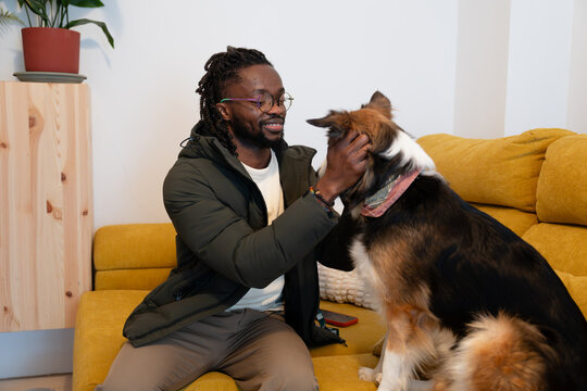 Man bonding with happy dog on sofa