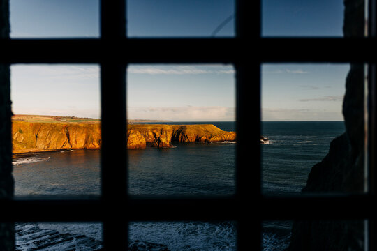 Scottish cliffs viewed through iron bars