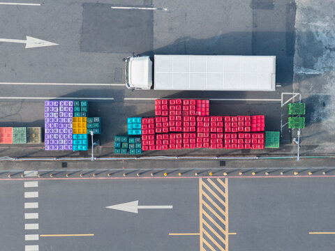 Colorful Plastic Crates Stacked by Truck Aerial View
