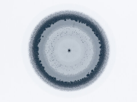 Drone shot of unique radial ice formations and snow on water, top view