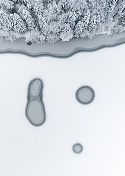 Frozen Lake With Circular Patterns and Tree Line Above