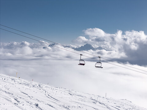 Ski Lift Moves Above Clouds in Snowy Mountain Area