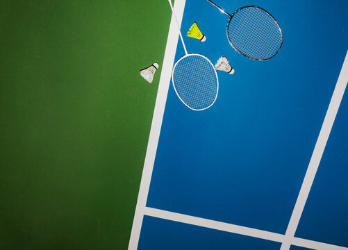 Badminton Rackets and Shuttlecocks on a Sports Court Surface