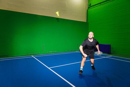 Man Plays Badminton in Indoor Sports Hall