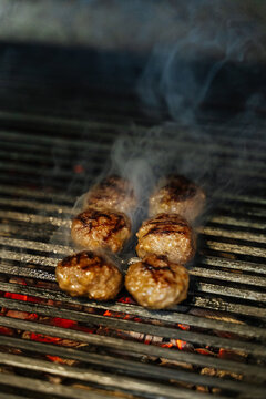 Meatballs grilling over hot charcoal