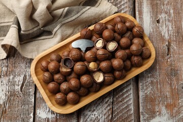 Fototapeta premium Macadamia nuts and metal key on wooden table, top view
