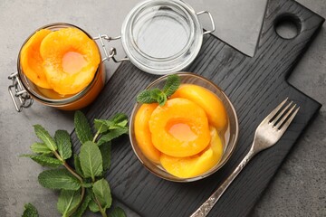 Pickled peaches and mint leaves on grey table, flat lay © New Africa