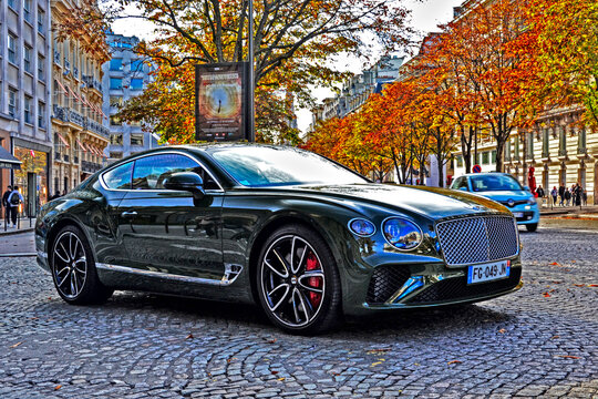 Paris, France &ndash; October 26th 2019: A brown Bentley Continental turning on Avenue George V, lined with colorful autumn trees in a sunny upscale district.