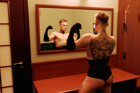 Person Flexing Muscles in Front of Mirror in a Changing Room