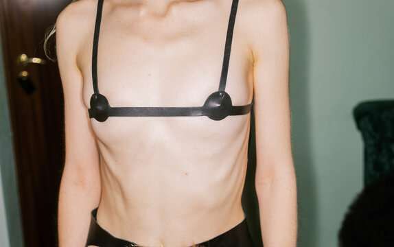 Part of female wearing  leather kink top