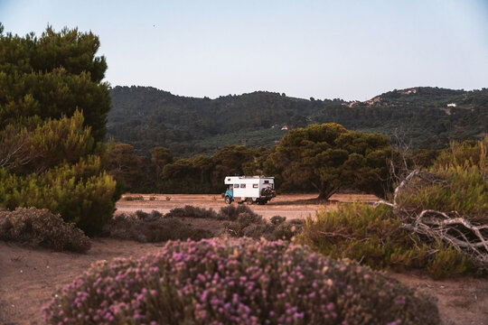 overland camper parked in mediterranean landscape with wildflowe