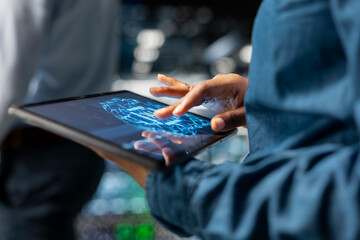 Close up of data center technician using tablet for maintenance on server rigs, handling AI processing tasks. Server hub data scientist managing storage arrays supporting deep learning tech.