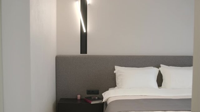 Modern minimalist bedroom with large bed and natural daylight.