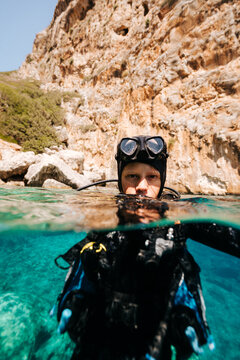Child scuba diver resting at surface in turquoise sea