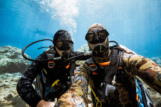 Father and son scuba diving together in clear Mediterranean wate