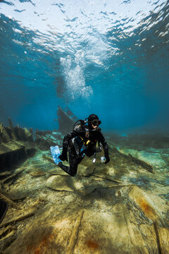 Young scuba diver hovering above historic shipwreck