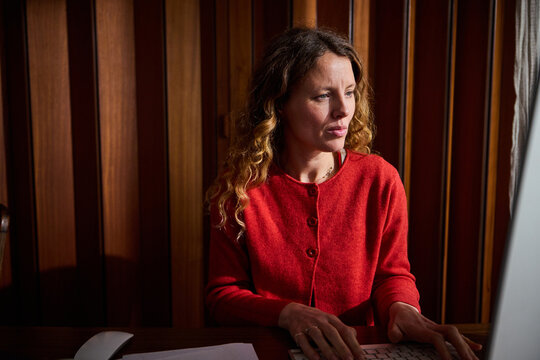 Woman types on a desktop computer