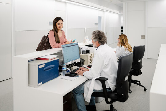 Patient checking in at hospital reception desk