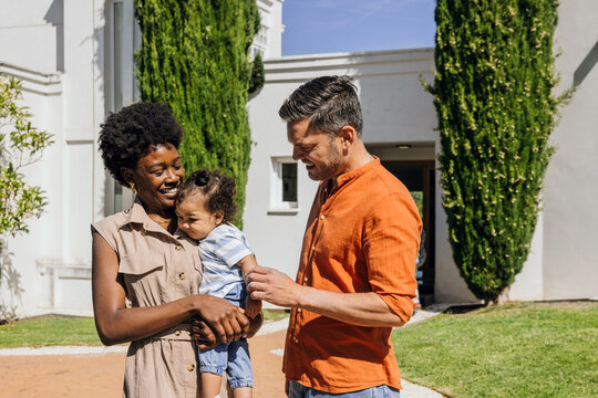 Family enjoying a sunny day in front of their home