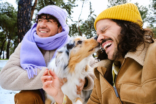 Couple Laughing as Dog Licks Man&rsquo;s Face Outdoors