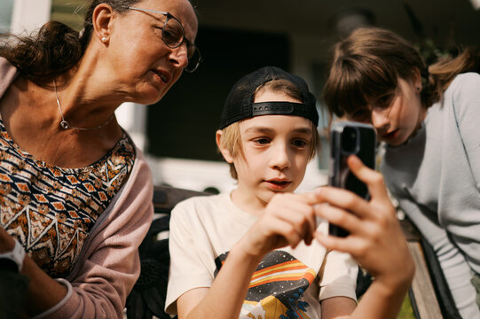 grandmother and grandchild sitting in yard looking at phone
