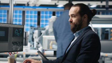 Professional engineer reviewing insight on pc at the solar panels plant, conducting an inspection...