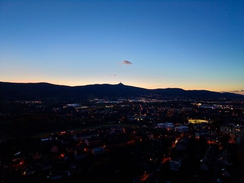 nightfall over cityscape suddenly descends, dusk illuminates city with peaceful atmospheric glow