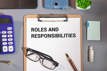 Fototapeta premium Sheet of paper with text Roles and Responsibilities on wooden background