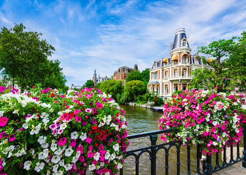 Canal in Amsterdam, Netherlands with flowers on a bridge
