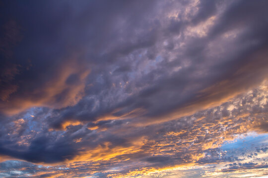 Dramatic beautiful sky background with clouds. Bottom-up view. Nature concept for design or for adding text. Abstract background with a natural sky. Close-up.
