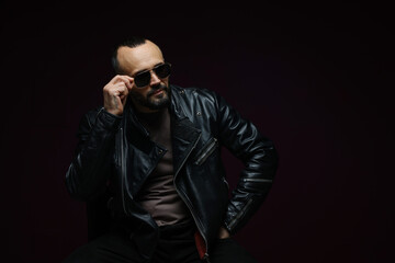 Obraz premium Fashion model. Handsome man in sunglasses on black background, space for text