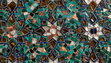 Detailed geometric mosaic texture constructed with green and brown stained glass shards
