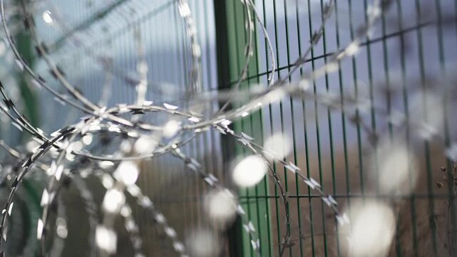 Barbed and razor wire on top of fence, selective focus dof