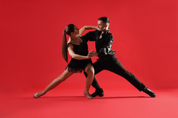 Couple of professional dancers on red background