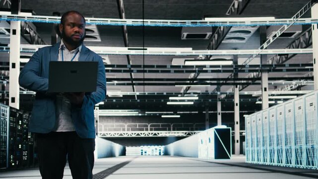 Optimizing electronics, laptop and team of software developers in server farm. Brainstorming, notebook and teamworking colleagues in data center monitoring system performance bottlenecks, camera A