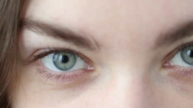 Macro view of young woman with beautiful eyes. Camera moving forward