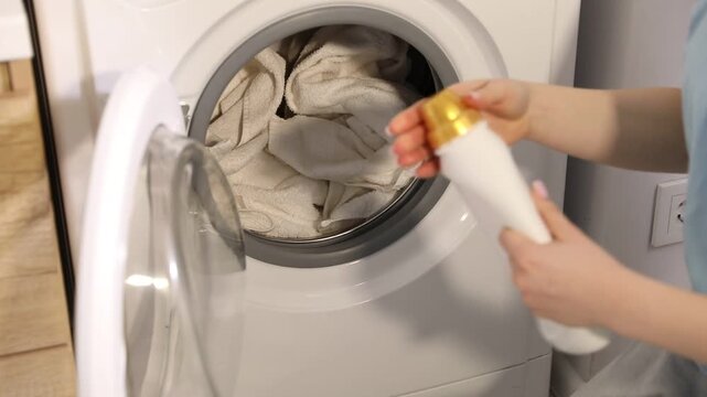 Woman adding detergent into washing machine at home, closeup