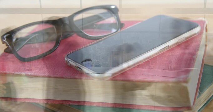 Phone resting on red book with glasses catching shifting blinds reflections, showing tech detail