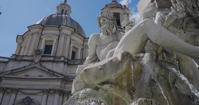 Close up of Bernini's Fountain of the Four Rivers and obelisk in front of Sant'Agnese in Agone church in Rome Italy, slwo motion