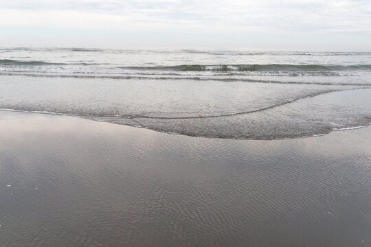 USA, WA, Queets, Olympic National park.  Waves lapping gently on the beach on the west coast of the Olympic Peninsula.  Looking west over the Pacific Ocean.