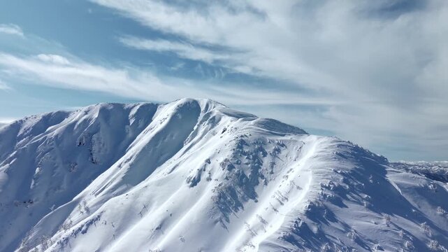 日本百名山の荒島岳　雪山ドローン映像　斜めに上昇しながら山頂が現れる