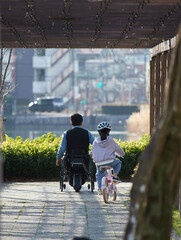 春の名城公園で車椅子を乗る男性と自転車を乗る幼女の姿
