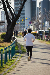 春の名城公園でランニングする若い男性の姿
