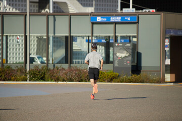 春の名城公園でランニングする中年男性の姿